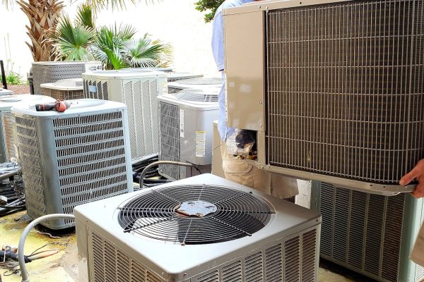 hvac technician removing old rusted broken airconditioners in HVAC at beach condo.